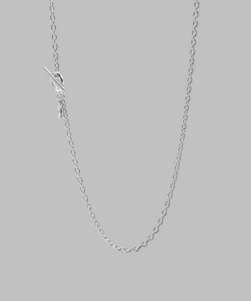 【Refined Chain Necklace/0.3AZUKI-リファインドチェーンネックレス/0.3アズキ-】 定番となったチェーンネックレスのスタイリング。 マンテル(留め具)には細身でプレーンなTバーを採用し、受け側には岩肌のようなゴツゴツとしたテクスチャーを施しました。 シルバーチェーンはロジウムメッキを施すことで上品な雰囲気に仕上がっています。 少し大きめのクラシカルなロゴプレートをワンポイント加えることで洗練された雰囲気に。 マンテルを前に持ってくるスタイリングでアクセントを加えてもOK。